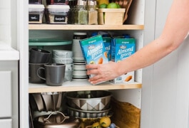 person putting Almond Breze Shelf Stable in pantry