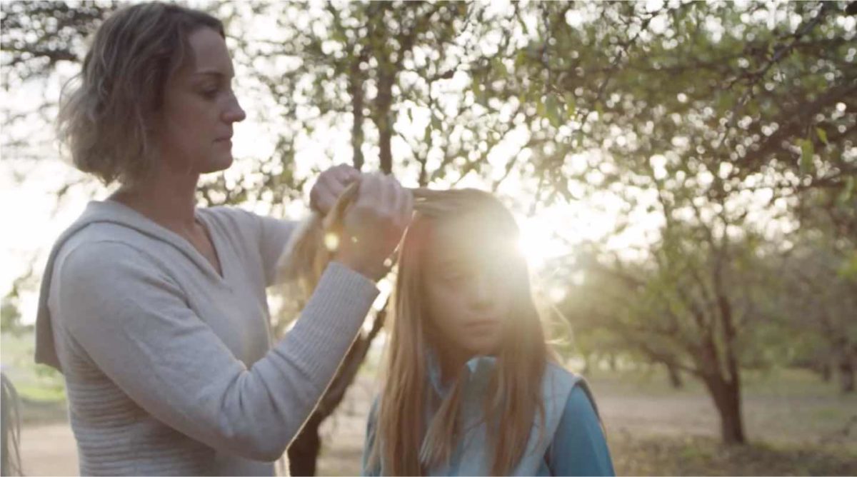 woman braiding daughter's hair